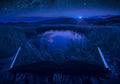 Mountain lake in a moon light on the pages of an open book Royalty Free Stock Photo