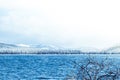 Mountain lake with rocks on the shore, winter fog over the water surface. Royalty Free Stock Photo