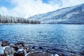 Mountain lake with rocks on the shore, winter fog over the water surface. Royalty Free Stock Photo