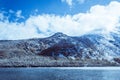 Mountain lake with rocks on the shore, winter fog over the water surface. Royalty Free Stock Photo