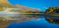 Mountain lake at sunrise in autumn. Landscape with lake, gold sunlight, blue fog over the water, reflection, trees with colorful Royalty Free Stock Photo