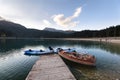 Mountain lake sunrise landscape.Old wooden boat and blue kayaks at the plank Royalty Free Stock Photo