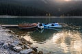 Mountain lake sunrise landscape.Old wooden boat and blue kayaks at the plank Royalty Free Stock Photo