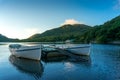 Mountain lake sunrise landscape with two traditional fishing boats Royalty Free Stock Photo