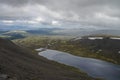 Mountain lake in valley with mosses and rocks covered with lichens. Cloudy sky before storm. Khibiny mountains above the Arctic Royalty Free Stock Photo