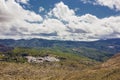 Mountain landscape on blue cloudy sky background. Picturesque landscape of the mountains glowing under sunlight.