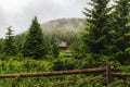 Mountain landscape in Carpathians, wooden house under hill in rain weather Ukraine. Royalty Free Stock Photo