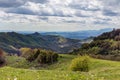 Mountain landscape in cloudy weather. Trees are changing color in the spring. Forest and green meadow in the foreground Royalty Free Stock Photo