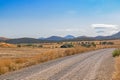 Mountain landscape. A country road passes by olive groves. In the distance, the turbines of a wind farm are visible Royalty Free Stock Photo