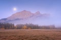 Mountain landscape at dawn. Fog in a valley. Field and forest in a mountain valley at dawn. Natural landscape with bright moon lig Royalty Free Stock Photo
