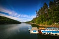 Mountain landscape with docks and pedal cycle boats on lake Gozna surrounded by forest at Valiug