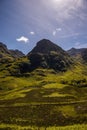 Mountain landscape in the Glencoe area in Scotland, Springtime view mountains with grassland and countryside road in the valley of Royalty Free Stock Photo