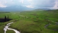 Mountain landscape with green fields intersected by a clear stream