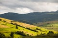 Mountain landscape with green and yellow grass and haystacks Royalty Free Stock Photo