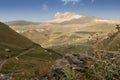 Mountain landscape - high orange rocky ridge away in fine sunny autumn day in bright golden sunbeams, hilly slope Royalty Free Stock Photo