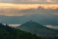 Mountain landscape immersed in fog, landscape after rain. Historical architecture looms in the background. Royalty Free Stock Photo