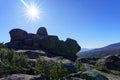 Mountain landscape with large granite rocks, blue sky and sun on the horizon with sun flare and desert atmosphere. Valdemanco,