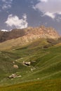 Mountain landscape - majestic colorful orange rocky cliff of canyon in sunbeams of sunny summer day, fluffy white clouds