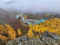 Mountain landscape in misty early morning in autumn. Fantastic view of the tops of mountain ridge above the clouds. Yellow larches Royalty Free Stock Photo