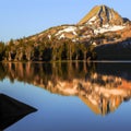 Mountain landscape in morning light with reflection in calm waters of the lake. Royalty Free Stock Photo