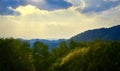 Mountain landscape of Northern Thailand. The sun`s rays are breaking through the clouds. Rainforest in the foreground. Royalty Free Stock Photo