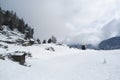 Alpine landscape with old sheds and a little snowman