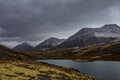 Mountain landscape. Rocky shore of a mountain lake on a rainy autumn day. First snow Royalty Free Stock Photo