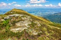 Mountain landscape with stones in the grass on hillside and blue Royalty Free Stock Photo