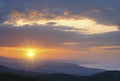 Mountain landscape at sunset. Amazing view from the mountain peak on rocks, low clouds, blue sky and sea in the evening. Colorful Royalty Free Stock Photo