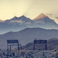 Mountain landscape at sunset -pair of empty benches.