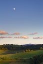 Mountain landscape at sunset. The slopes of the mountains in the evening light. Moon in the evening sky over the mountains Royalty Free Stock Photo