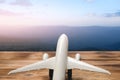 Mountain landscape with a view of the forest and white model of passenger plane on old wooden background.