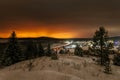 Mountain landscape with village in winter, houses and pine trees covered snow at night. Scenery of ski resort with lights Royalty Free Stock Photo