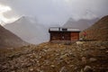 Mountain landscape with a wooden house in the middle of the road Royalty Free Stock Photo