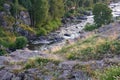 Mountain landscapes of the river running along the rocky shores on the banks of growing forest Royalty Free Stock Photo