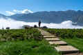 Mountain and low clouds view with stone walking steps and traveller taking landscape photo in Sapa town, Vietnam