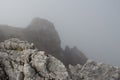 Mountain massif through dense fog, Dolomites, Italian Alps Royalty Free Stock Photo