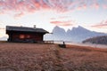 Mountain meadow and house Alpe di Siusi or Seiser Alm in the background Langkofel mountain range at sunrise with Province of Royalty Free Stock Photo