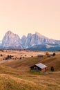 Mountain meadow and house Alpe di Siusi or Seiser Alm in the background Langkofel mountain range at sunset with Province of Royalty Free Stock Photo