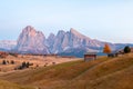 Mountain meadow and house Alpe di Siusi or Seiser Alm in the background Langkofel mountain range at sunset with Province of Royalty Free Stock Photo