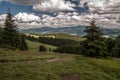 Mountain meadow with trees, hills panorama and nice sky with clouds in Beskid Zywiecki mountains