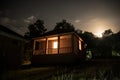 Mountain night landscape of building at forest at night with moon or vintage country house at night with clouds and stars. Summer Royalty Free Stock Photo