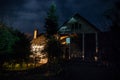 Mountain night landscape of building at forest at night with moon or vintage country house at night with clouds and stars. Summer Royalty Free Stock Photo