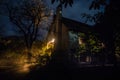 Mountain night landscape of building at forest at night with moon or vintage country house at night with clouds and stars. Summer Royalty Free Stock Photo