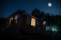 Mountain night landscape of building at forest at night with moon or vintage country house at night with clouds and stars. Summer Royalty Free Stock Photo