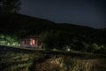 Mountain night landscape of building at forest at night with moon or vintage country house at night with clouds and stars. Summer Royalty Free Stock Photo
