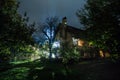 Mountain night landscape of building at forest at night with moon or vintage country house at night with clouds and stars. Summer Royalty Free Stock Photo