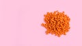 A mountain of orange pills lies on a pink background Royalty Free Stock Photo