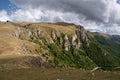 Mountain overgrown in grass with rocky cliffs