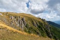 Mountain overgrown in grass with rocky cliffs